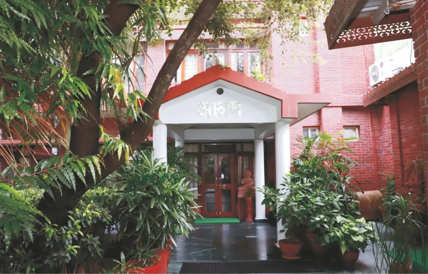 Entrance of the Maharishi Yoga Ashram building surrounded by trees